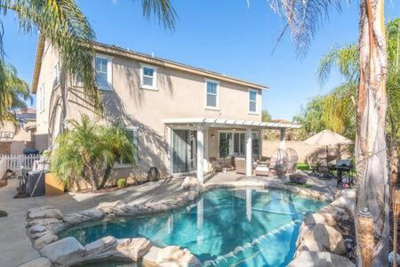 a house with a swimming pool in front of a house at Minutes to Wineries Outdoor Oasis Pool Table in Murrieta