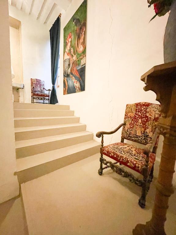 een trap met een stoel en een schilderij aan de muur bij Chateau Bourgeoisie *** in Laimont