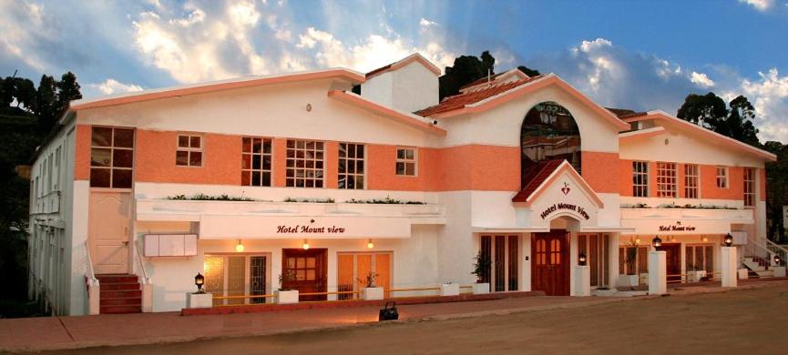 un gran edificio naranja y blanco en una calle en Hotel Mount View, en Kodaikanal