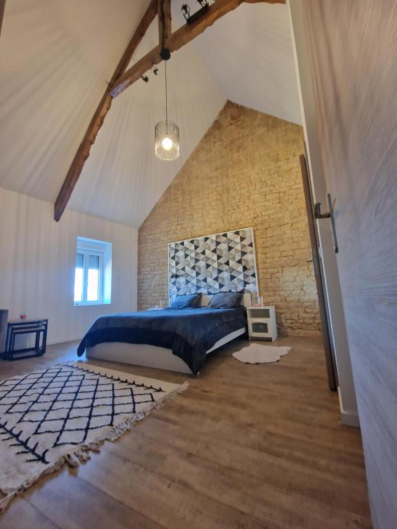 a bedroom with a bed and a brick wall at villa proche de coursseulles sur mer 