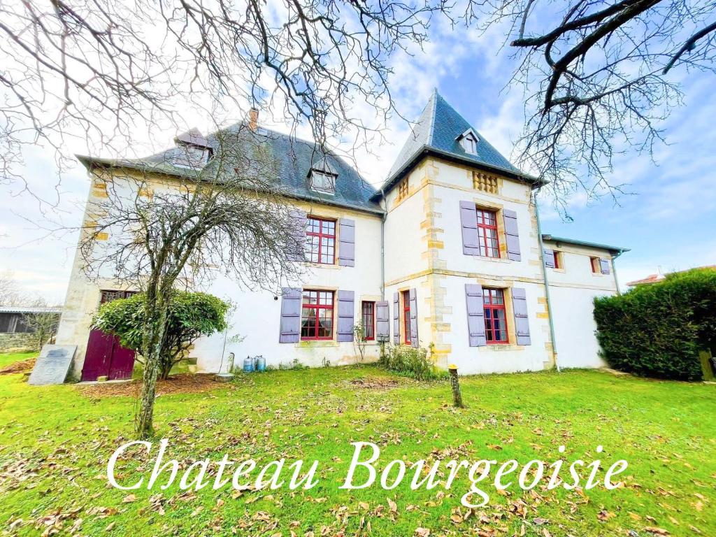 にあるChateau Bourgeoisie ***の緑地の赤窓付き白い大家