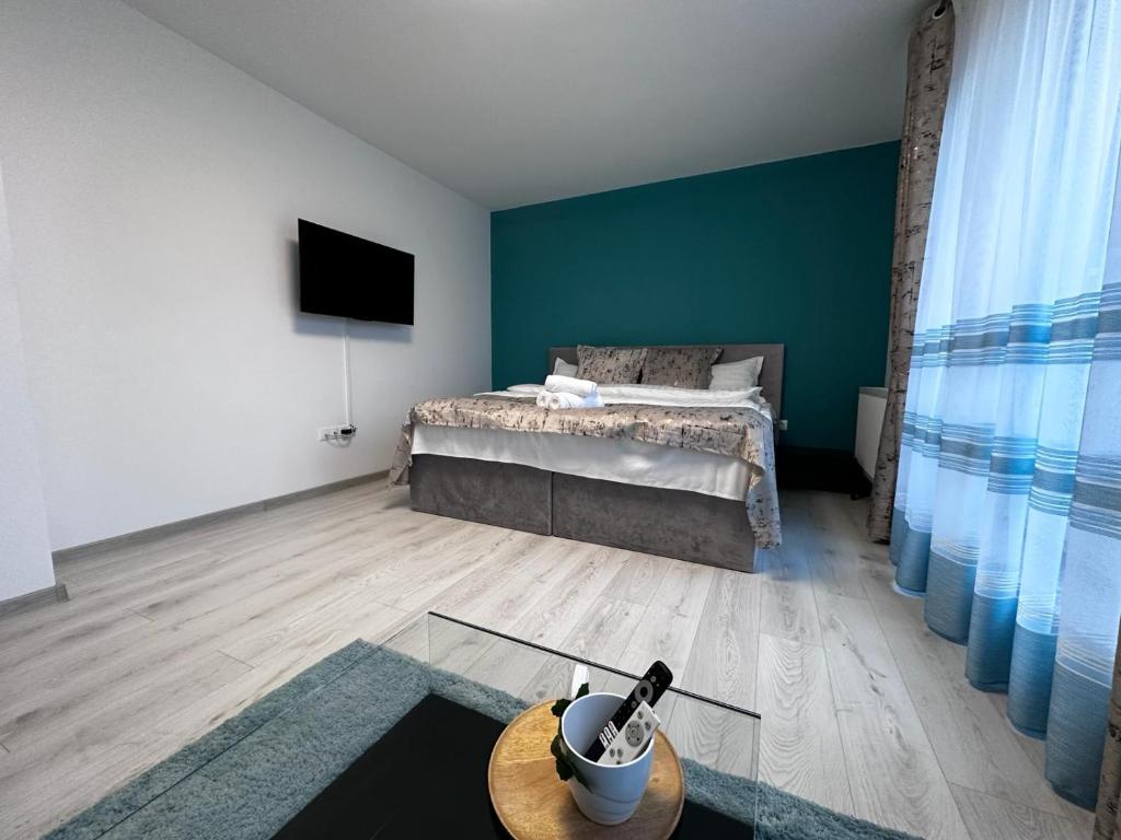 a bedroom with a bed and a table and a tv at elisio - Glide Studio in Braşov