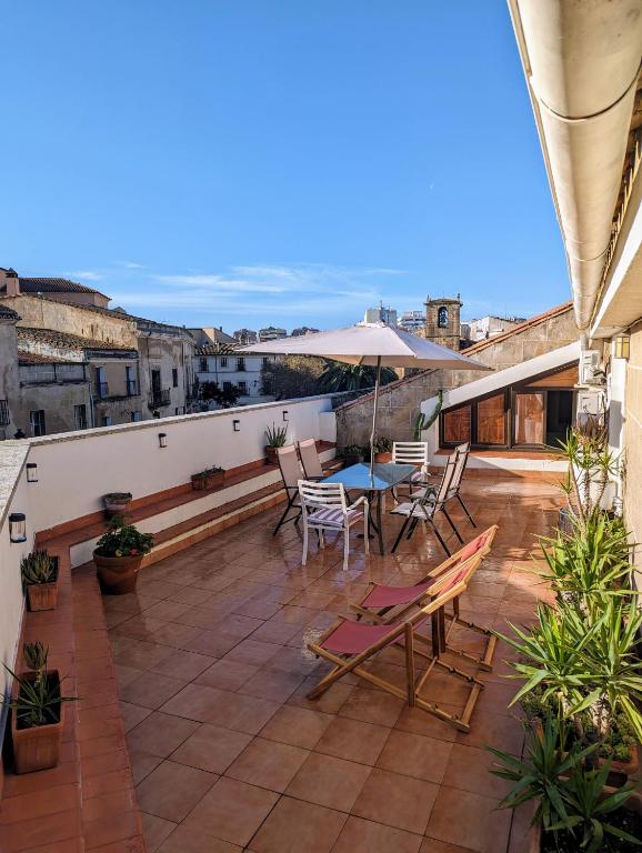 a patio with a table and chairs on a roof at Ático San Juan 2 in Cáceres