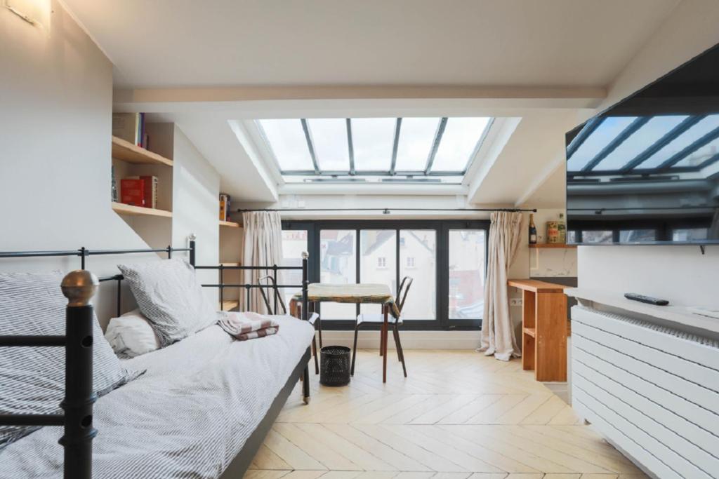 Zimmer mit einem Bett und einer Küche mit einem Fenster in der Unterkunft Amazing Mazarine Studio in Paris