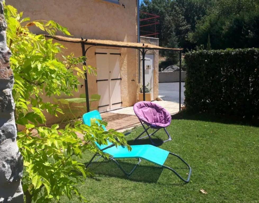 two chairs sitting in the grass in a yard at Gîte La vue étoilée in Curbans