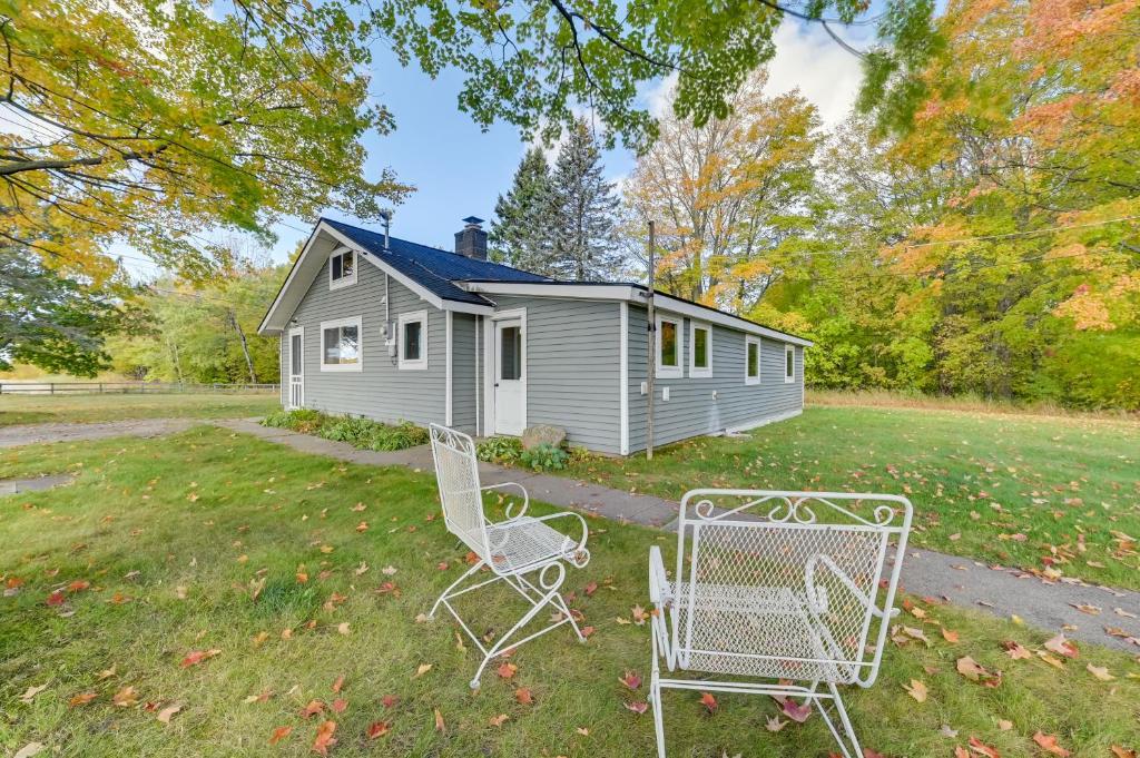 una casa con dos sillas frente a un patio en Cozy Harbor Springs Vacation Rental, 13 Mi to Town, en Harbor Springs