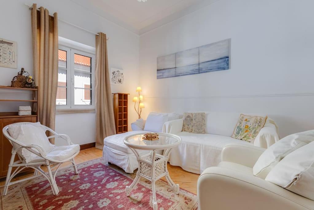 a living room with a white couch and a table at Requinte e bom gosto para 6 pessoas no coração de Faro in Faro