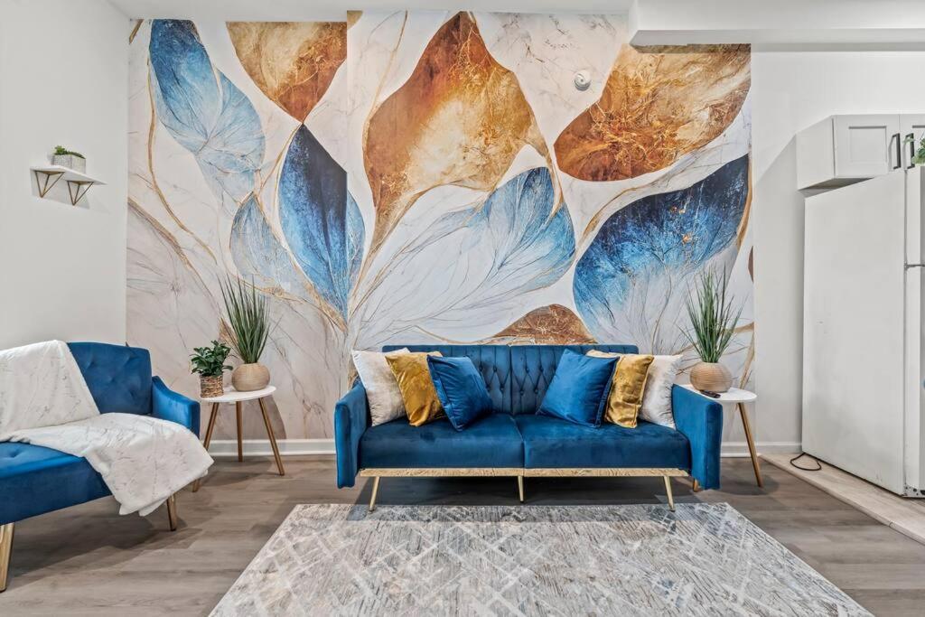 a living room with a blue couch and a mural at The Blue Luxe Apartment West Philadelphia, 10mins Center City, Free Parking in Philadelphia