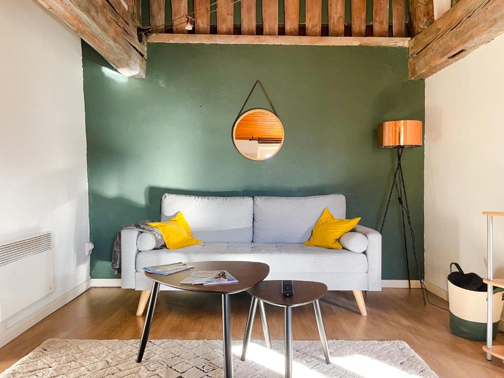 uma sala de estar com um sofá e uma mesa em Appartement. Le Joyau de Courtejaire em Carcassonne