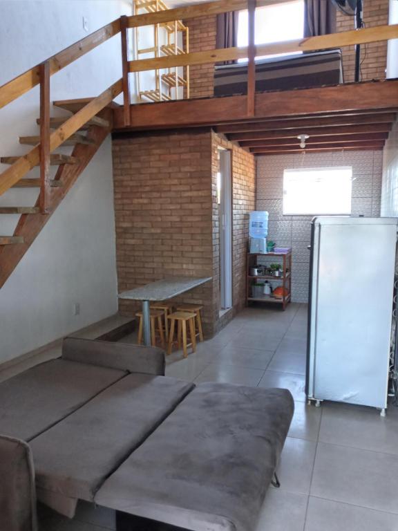 Cette chambre dispose d'un canapé, d'un réfrigérateur et d'une table. dans l'établissement Apartamento-Chalé, à Prado