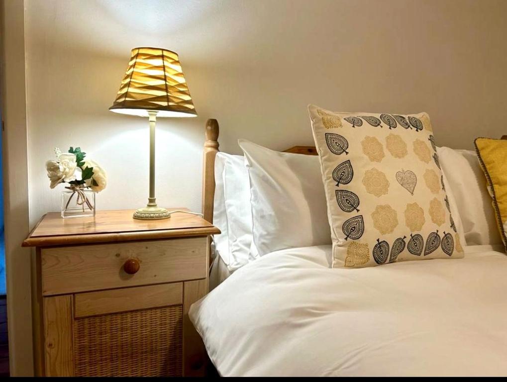 a bedroom with a bed with a lamp on a night stand at Melody Rowe One Bed Free Wi-Fi Garden Fireplace 