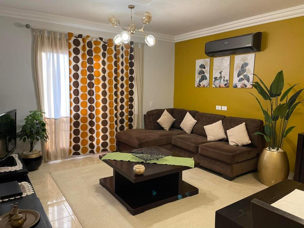 ein Wohnzimmer mit einem Sofa und einem Tisch in der Unterkunft Quiet and distinctive apartment with a wonderful v in Madinaty