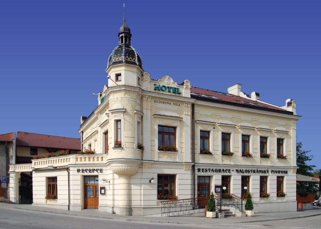 a large white building on the corner of a street at Hotel Jelínkova vila in Velké Meziříčí