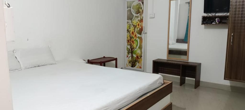 a bedroom with a white bed and a mirror at Ocean front beach resort in Tajpur