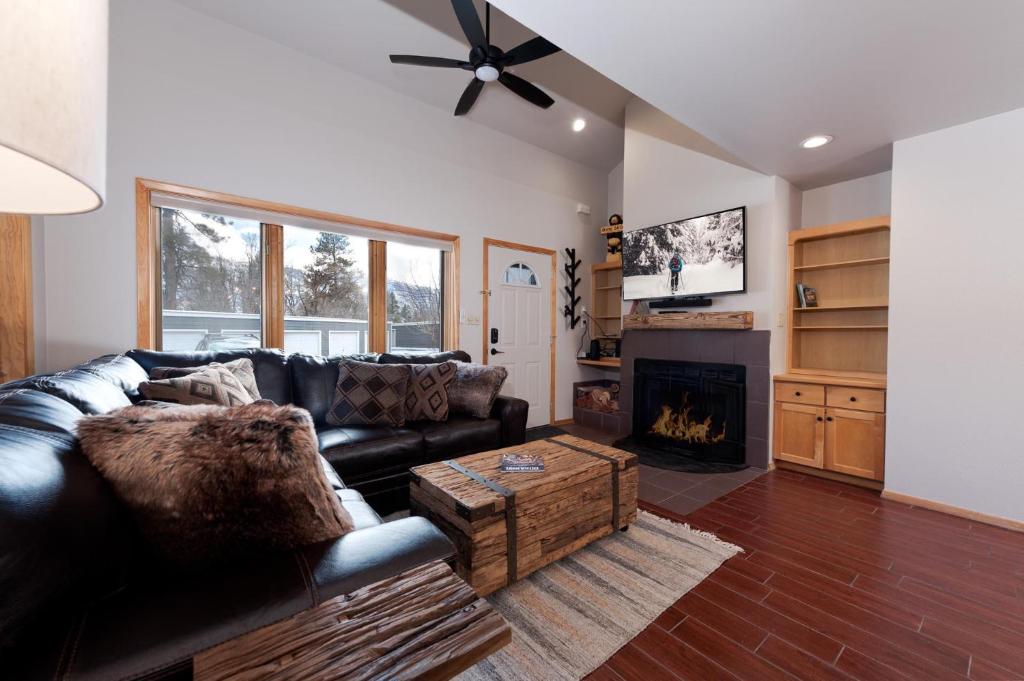salon z czarną skórzaną kanapą i kominkiem w obiekcie Pine Acres - Unit 123 w mieście Durango