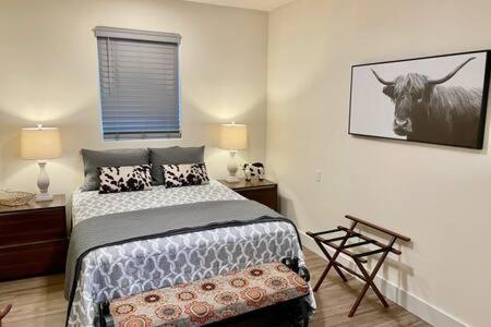 1 dormitorio con 1 cama y una foto de una vaca en la pared en Crazy Cow Private HOT TUB BBQ Sleeps 2, en Ahwahnee
