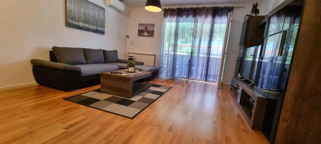 City Style Apartment-New Zagreb في زغرب: غرفة معيشة بها أريكة وتلفزيون