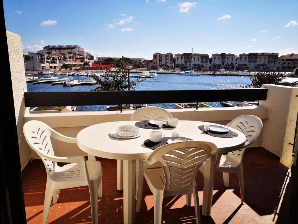 d'une table et de chaises sur un balcon avec vue sur le port. dans l'établissement Résidence Palmyra - T2 5 PERS - LE BARCARES- piscine incluse MAE-3964, au Barcarès