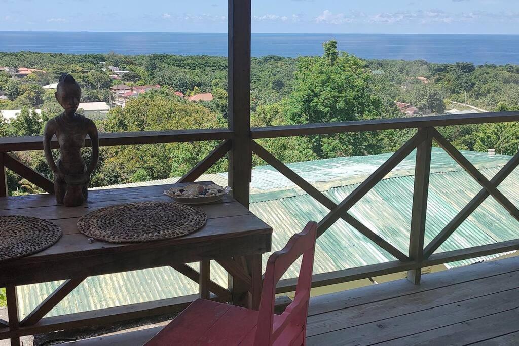 a table on a balcony with a view of the ocean at Backra`s Villa in Port Antonio