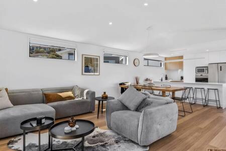 a living room with two couches and a kitchen at Mountain View Villa-close to shops-10min to CBD in Bellerive