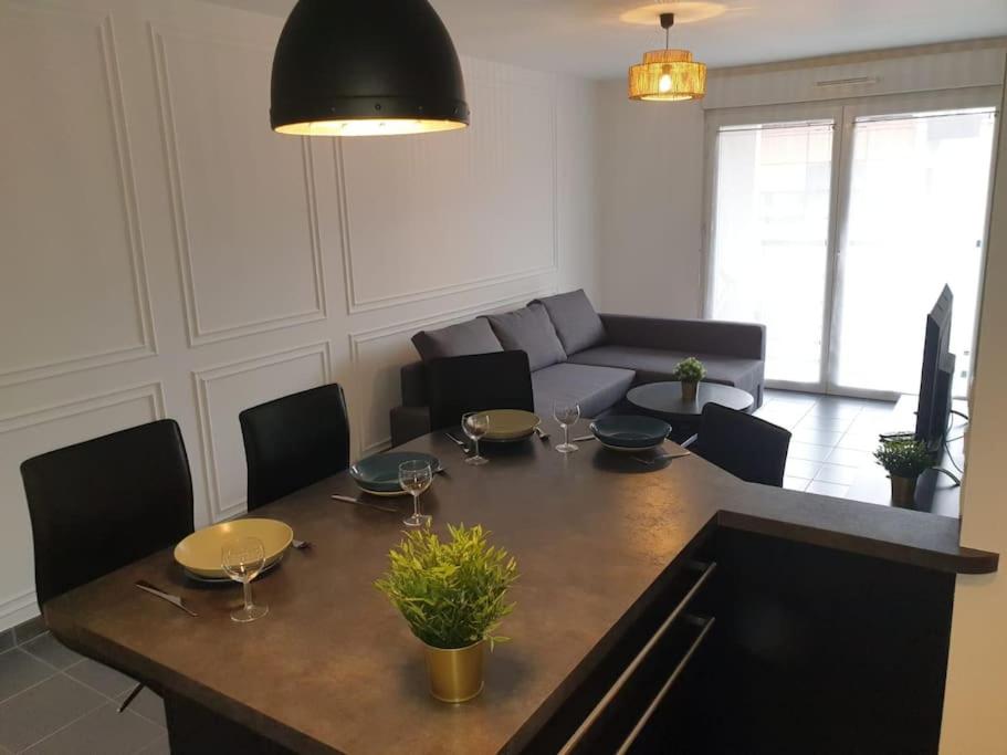 a living room with a table and a couch at Superbe appartement Evry Centre in Evry-Courcouronnes