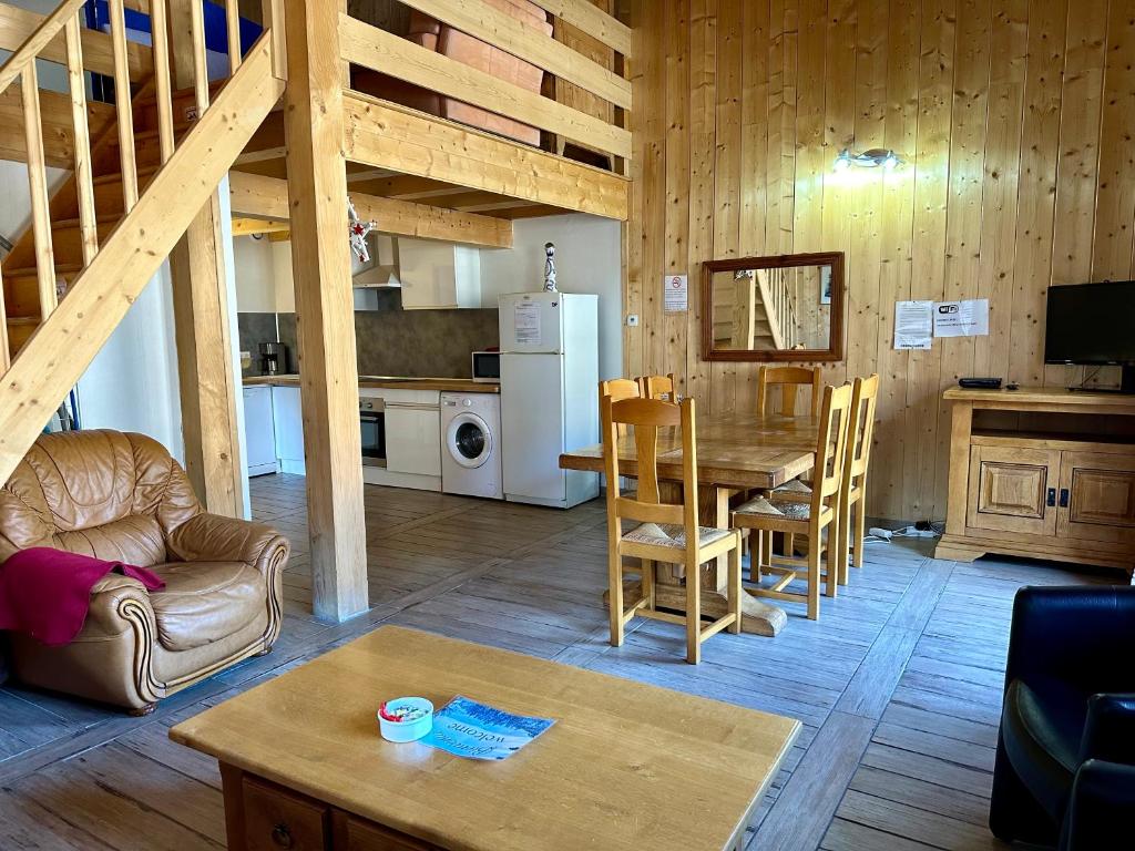 ein Wohnzimmer mit einem Tisch und einer Küche in der Unterkunft Appartement T3+Mezzanine CHARLOTTE in Courchevel