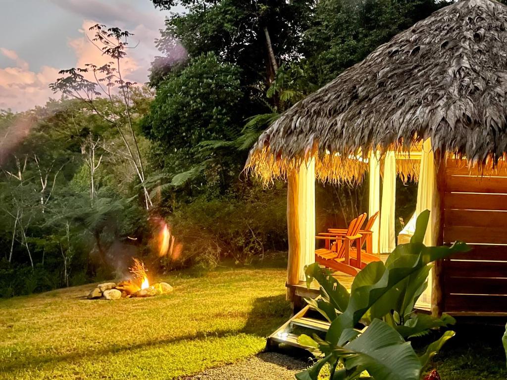 una cabaña con fuego en el césped en Wood cabin in the jungle with sea view, en Puerto Jiménez