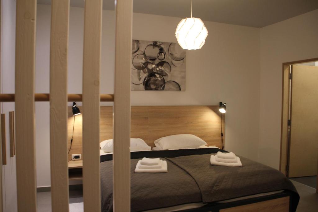 een slaapkamer met een bed met een houten hoofdeinde bij Maks Osijek in Osijek