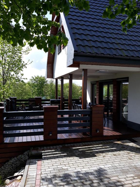 a house with a porch with a roof at Leśny Zakątek- Domek Lipa in Parchowo
