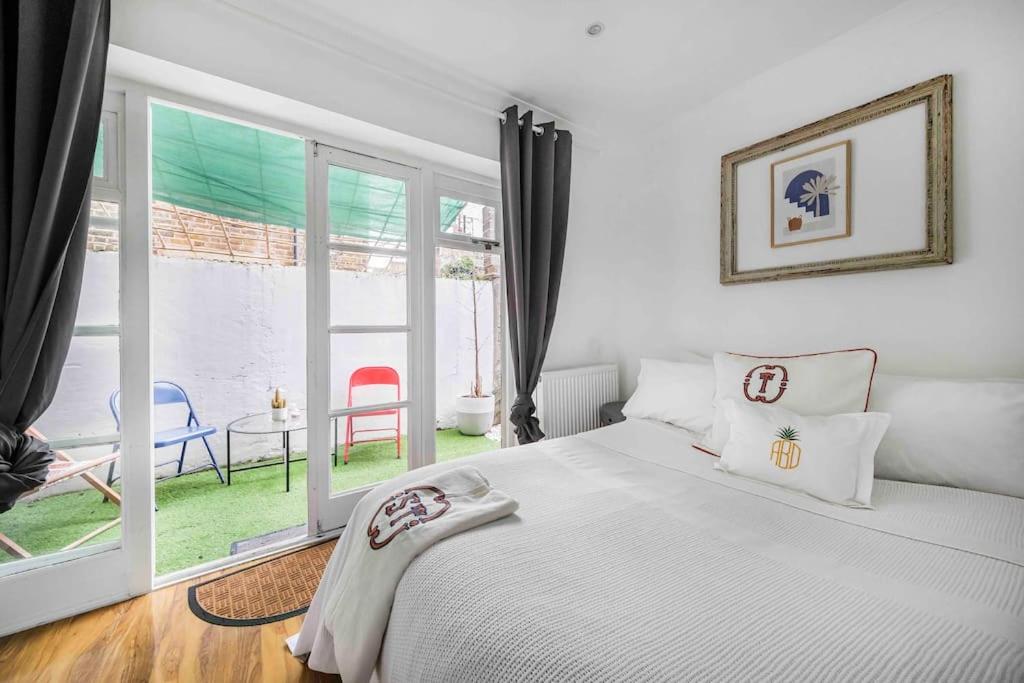 sypialnia z białym łóżkiem i dużym oknem w obiekcie UNIQE 2 Bedroom PRIME LOCATION w Londynie