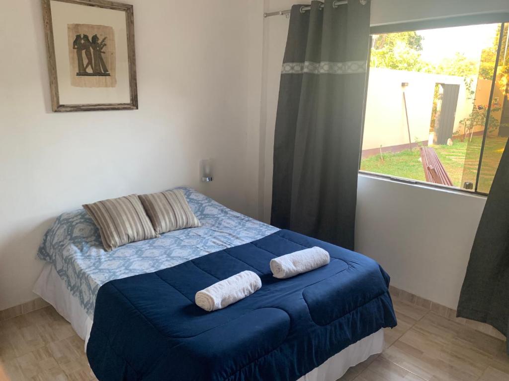 a bedroom with a bed with blue sheets and a window at CASAFUERTE departamentos in Luque