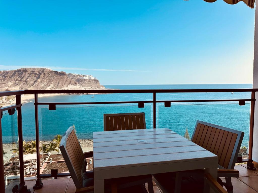 a table and chairs on a balcony with the ocean at APARTMENT WITH OCEAN VIEW in Playa del Cura