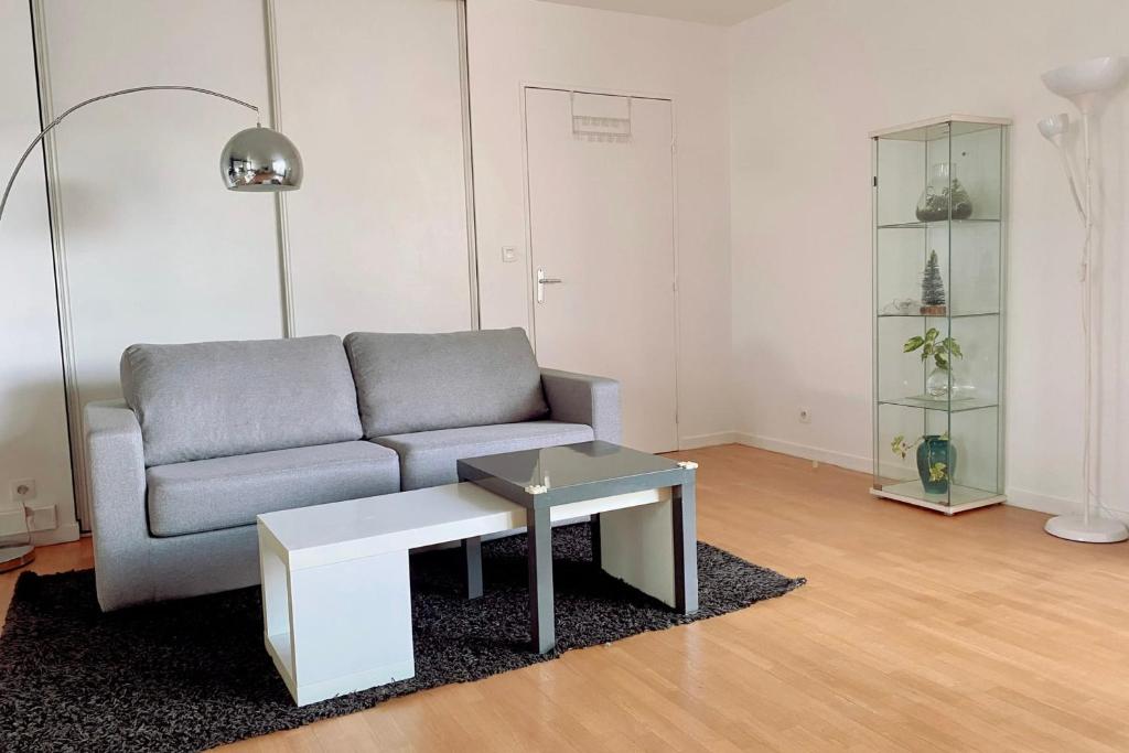 - un salon avec un canapé et une table dans l'établissement Comfortable 50 m apartment with parking, à Courbevoie