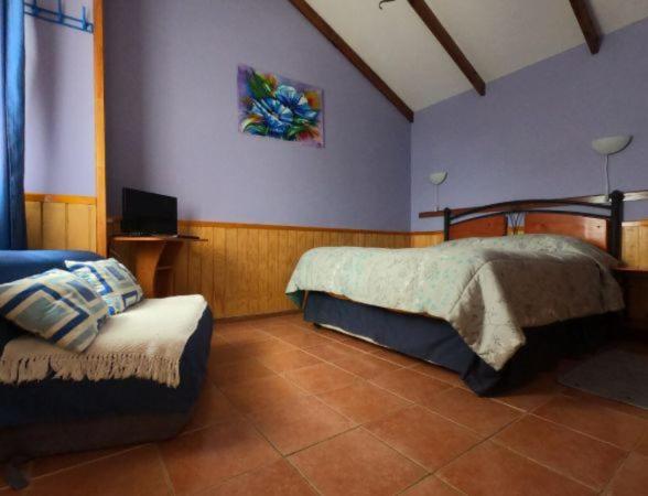 1 dormitorio con 1 cama y TV en la pared en Cabañas y departamento cerca en primera línea de la playa, en Punta de Choros