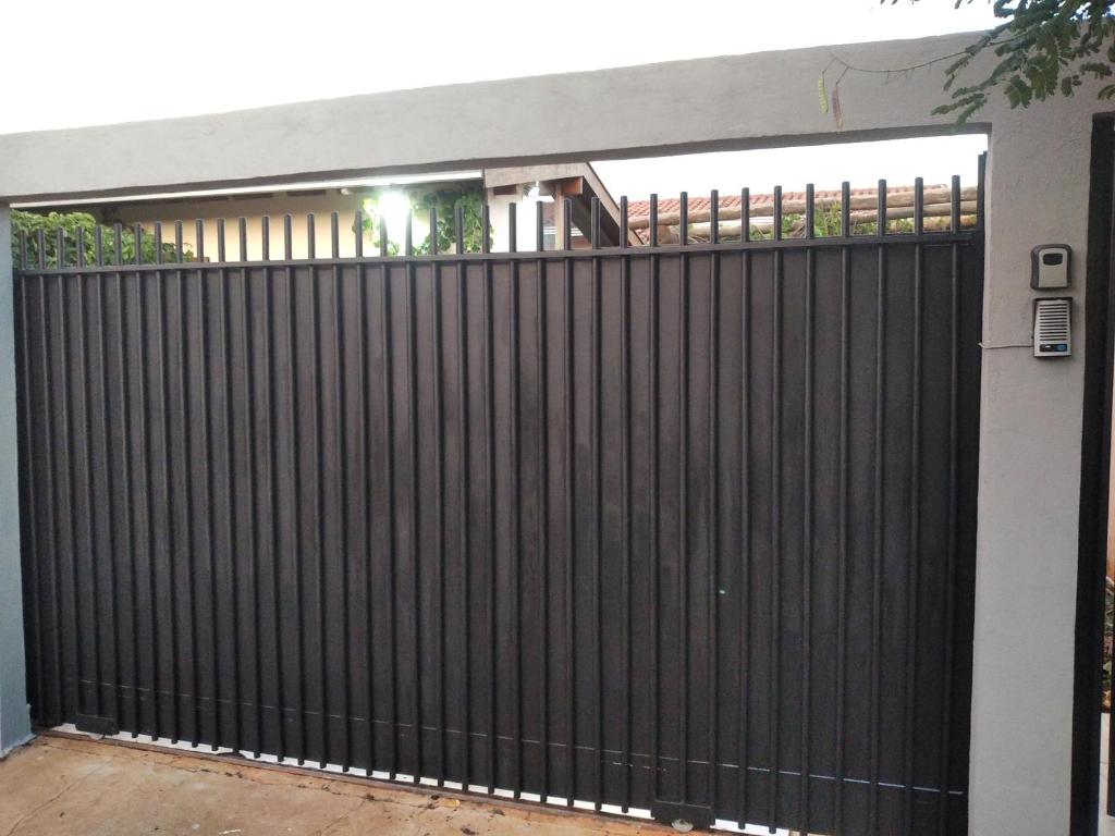 a black fence in front of a house at CASA INTEIRA MOBILIADA Próx Shopping Norte com Ar e Wifi , Selfie Checkin e Tv FireAmazon in Londrina