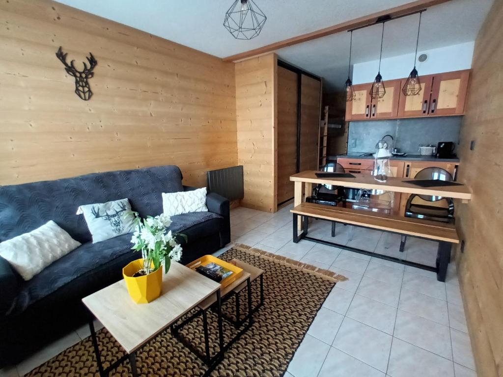 a living room with a couch and a table at appartement montagne- le petit Chaillol in Saint-Michel-de-Chaillol