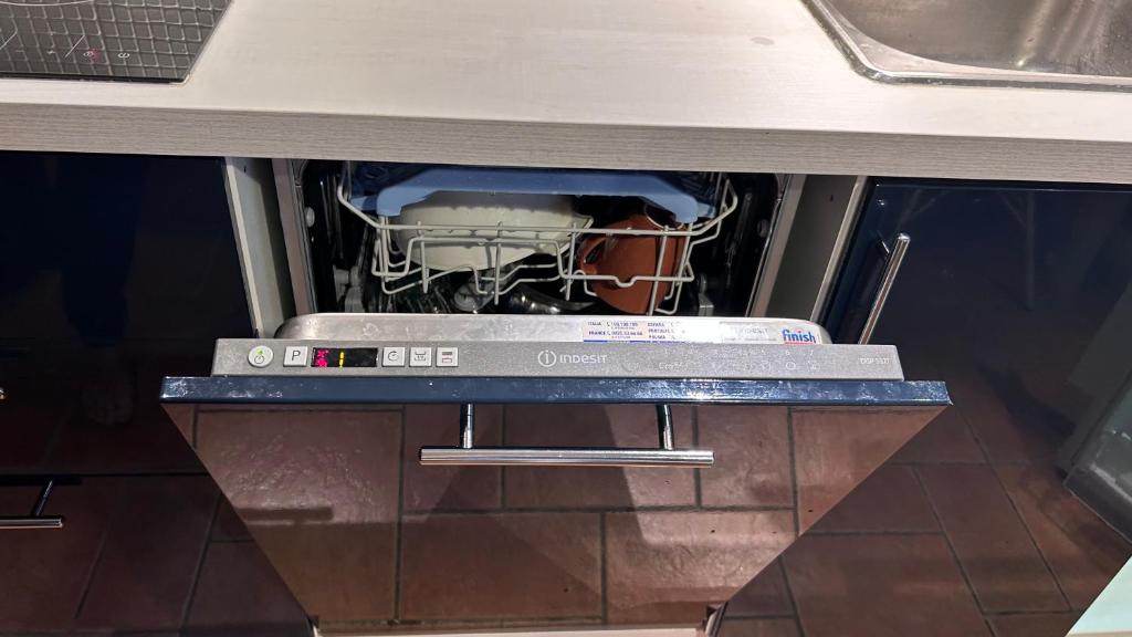 uma máquina de lavar louça numa cozinha com um cesto de pratos em Laakson Helmi 2 ,separate sauna, fireplace, lake em Himos