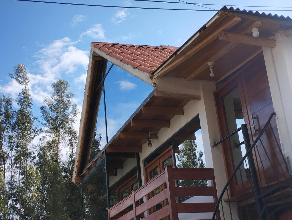 ein Haus mit einem roten Dach und einem Balkon in der Unterkunft Chullpa's House in Urubamba