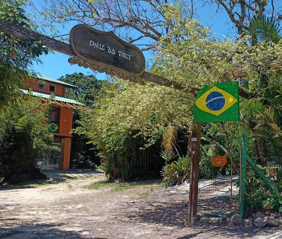 a sign for a club noitzitz sign with a flag at Chalé do Tibet Vale da Utopia in Guarda do Embaú