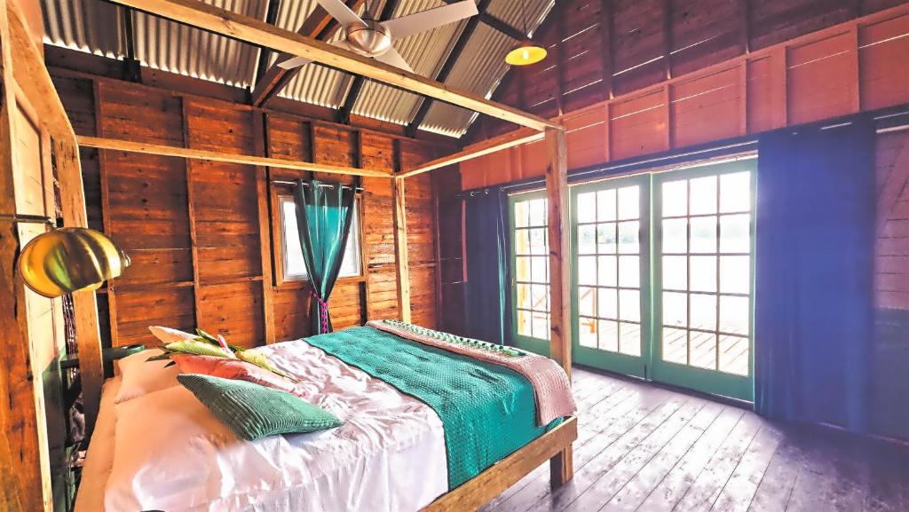 a bedroom with a bed in a room with wooden walls at The Sea Monkey in Bocas del Toro