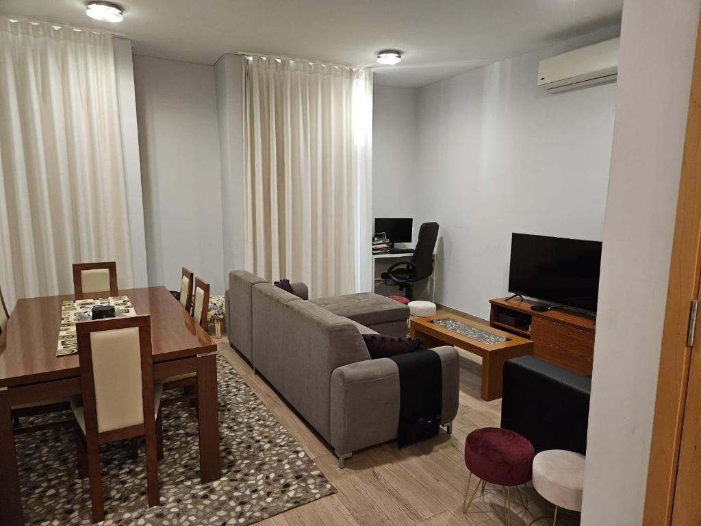 ein Wohnzimmer mit einem Sofa und einem Tisch in der Unterkunft Apart Nel in Praia
