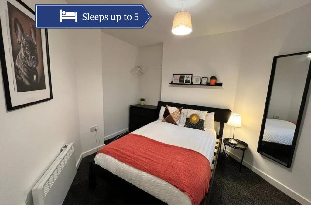 een slaapkamer met een bed met een rode deken bij Boutique 2Bed Apt with Great Amenities in Liverpool