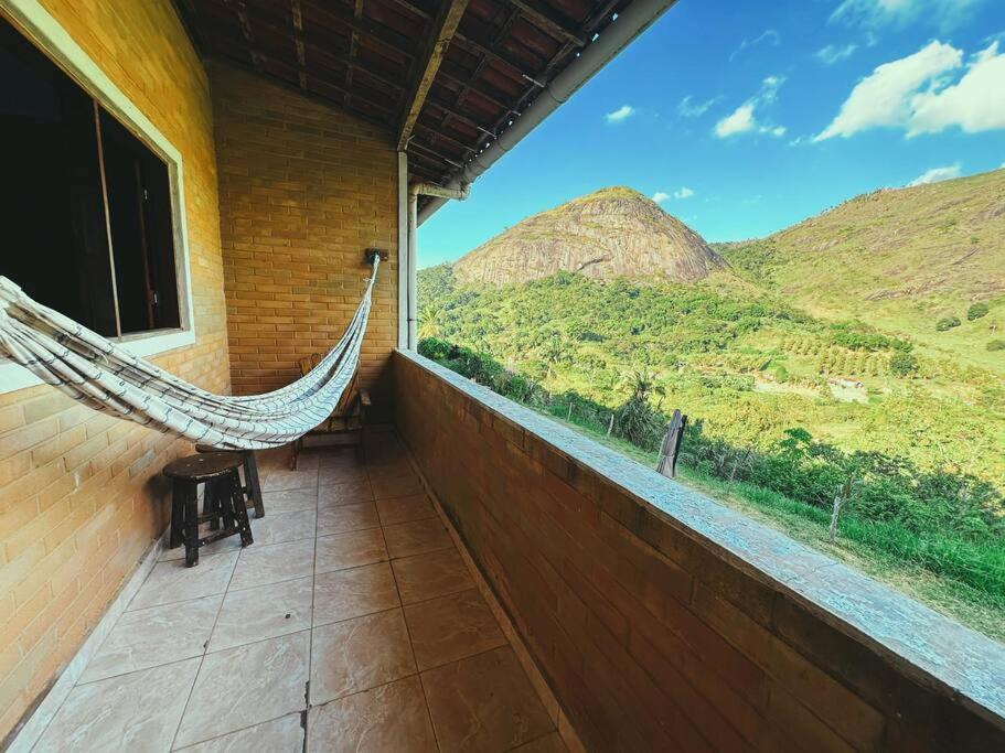 a hammock on a porch with a view of mountains at Eco Flat 322 - Hotel Fazenda Pedra do Rodeadouro in Bonito