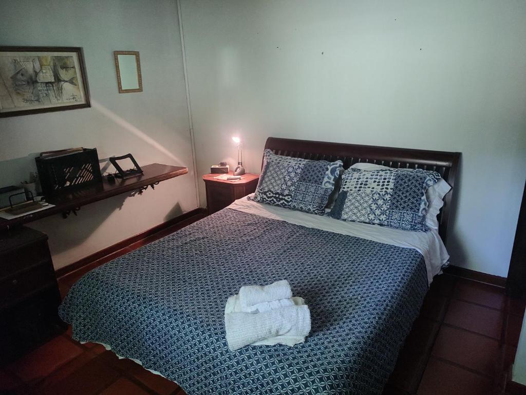 1 dormitorio con 1 cama con 2 toallas en Chalé em Itaocaia Valley Itaipuaçu Maricá RJ, en Maricá