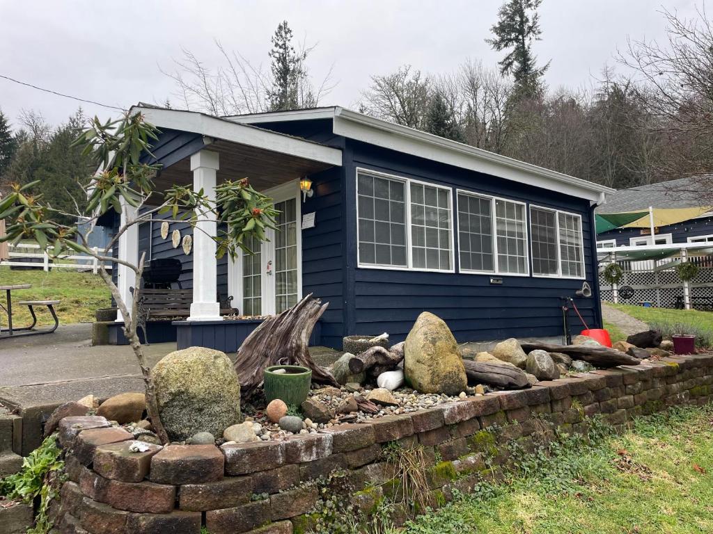 a small blue house with a rock garden in front of it at Beach Casita - Allyn Inn in Shelton