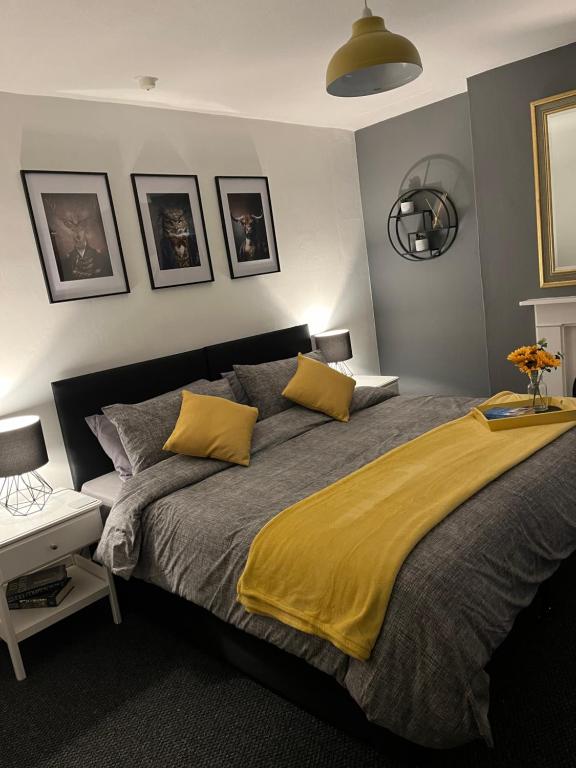ein Schlafzimmer mit einem großen Bett mit gelber Bettwäsche in der Unterkunft St James 3 bedroom House in Tunbridge Wells in Royal Tunbridge Wells