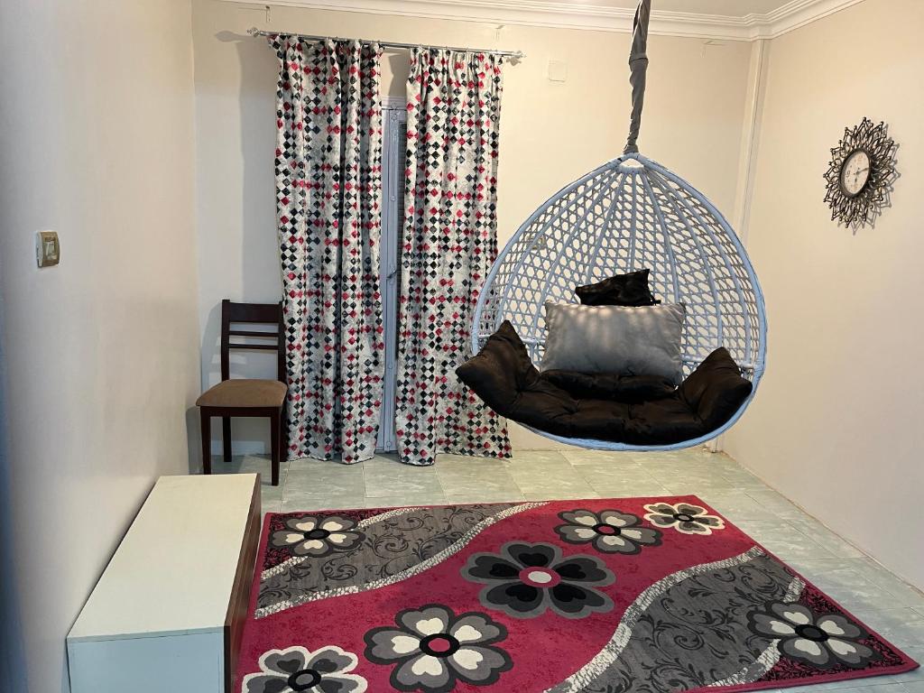 a swing in a room with a rug at 14 Min from cairo airport in Cairo