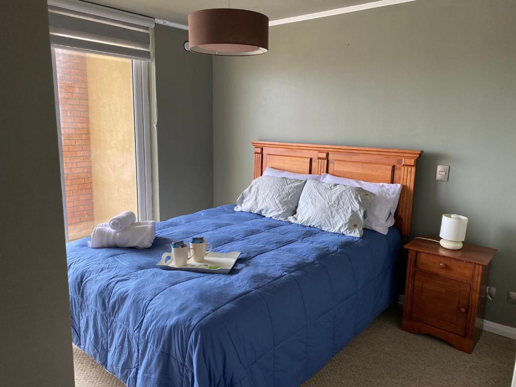 1 dormitorio con cama azul y edredón azul en Hermoso Departamento en Puerto Montt, en Puerto Montt