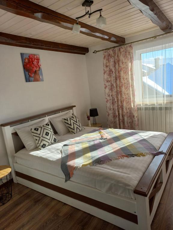 una camera da letto con un grande letto bianco e una finestra di White House a Slavske