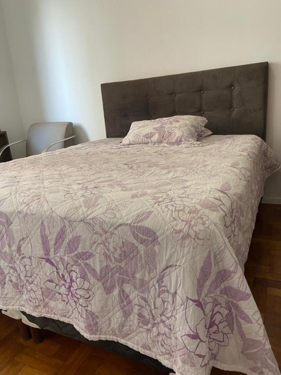 a bedroom with a bed with a purple comforter at Apartamento Praça da Liberdade in Belo Horizonte